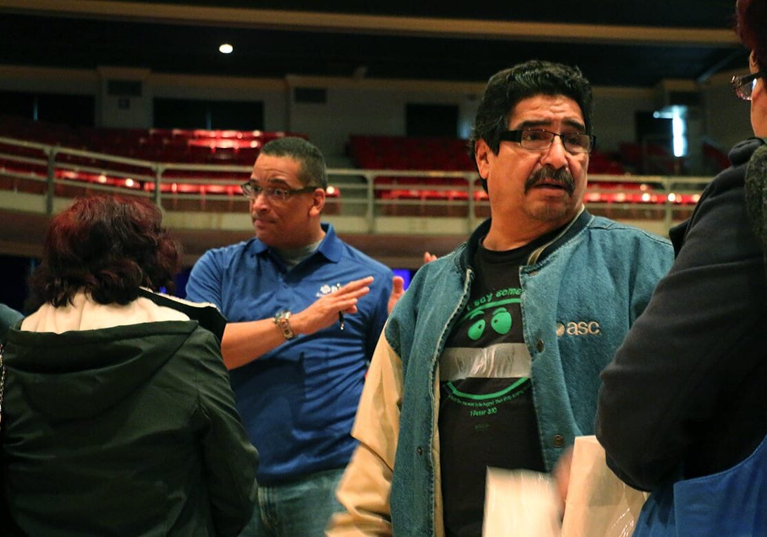 Renan Raven (left), a marketing specialist with Blue Cross and Blue Shield of Kansas City, provided answers about health insurance at a Saturday health fair in Kansas City, Kan. Raven is bilingual, and he was in high demand from the large number of Hispanics who attended the fair. (Photo by Mike Sherry/The Hale Center for Journalism)