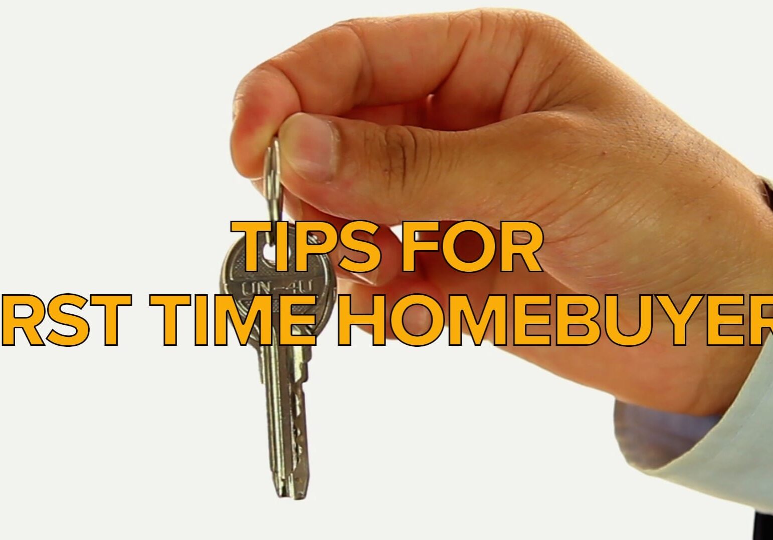 A hand holding keys to a house.