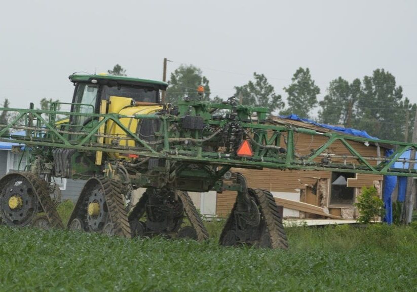 A farm tractor rolls along outside a Silver City, Miss., neighborhood in May. Mississippi lawmakers want the state to join the growing list of those regulating foreign ownership of agricultural land next year.
