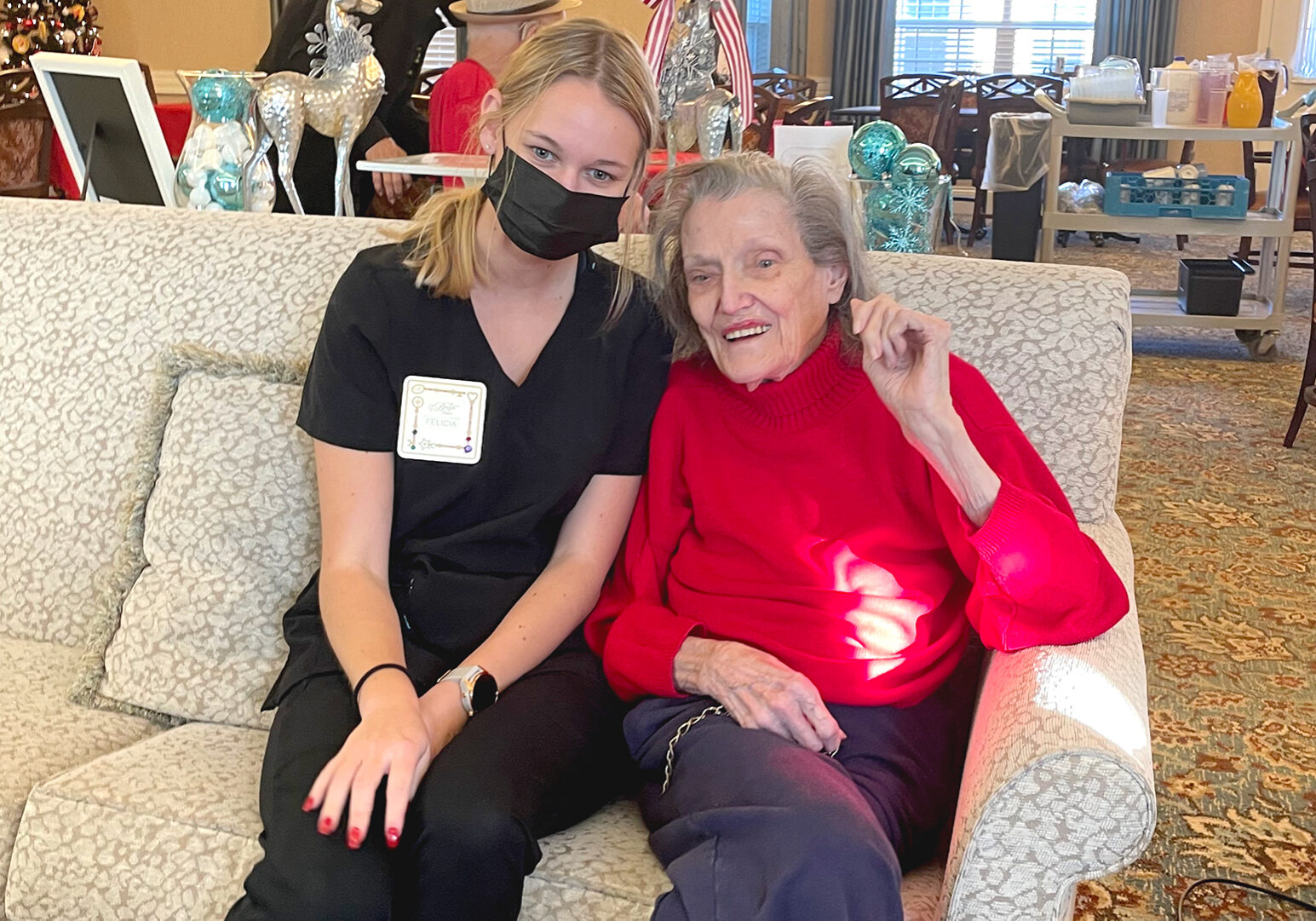 Felicia Honey, a nursing assistant, poses with a nursing home resident. Honey is a college student who's helped at Benton House of Lenexa during the historic staffing shortage.