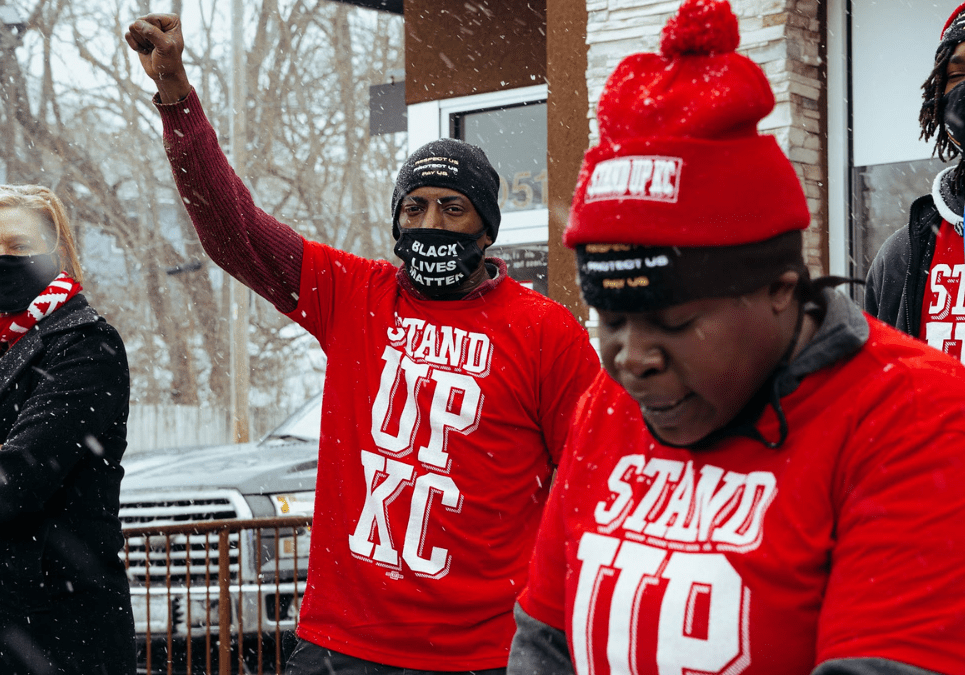 McDonald's worker Terrence Wise holds his fist up in solidarity as Fran Marion, another local McDonald's worker, speaks at the Fight for $15 rally on Jan. 15 in front of the Van Brunt McDonald’s in Kansas City,