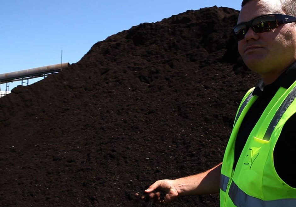 Man next to compost pile.