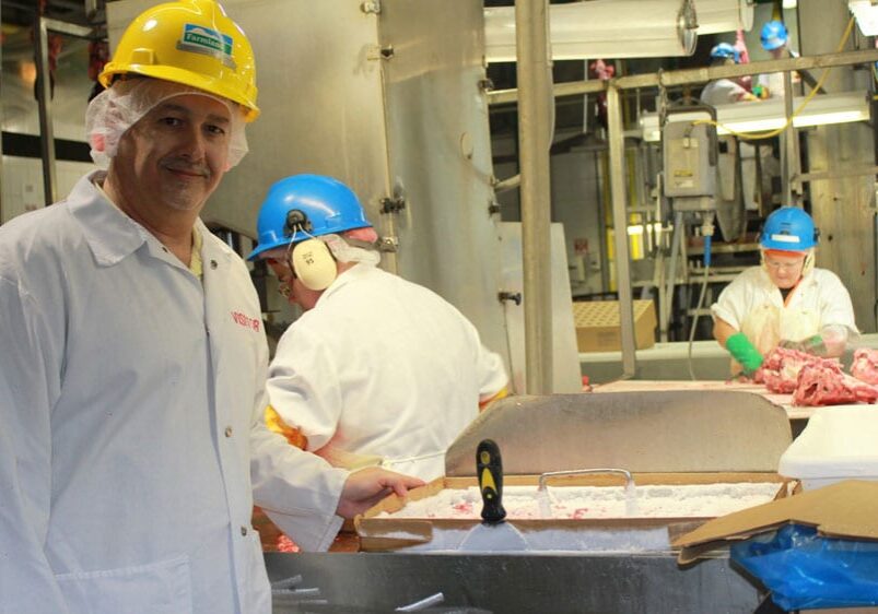 A worker looks out from the control room onto the rendering section of the Farmland Foods plant near Milan, Mo. (Peggy Lowe/Harvest Public Media)