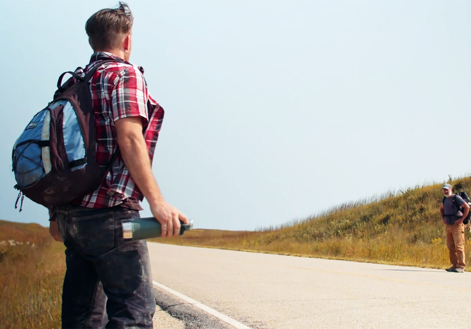 A scene showing to hitchhikers on a highway from "Found Wandering Lost,"