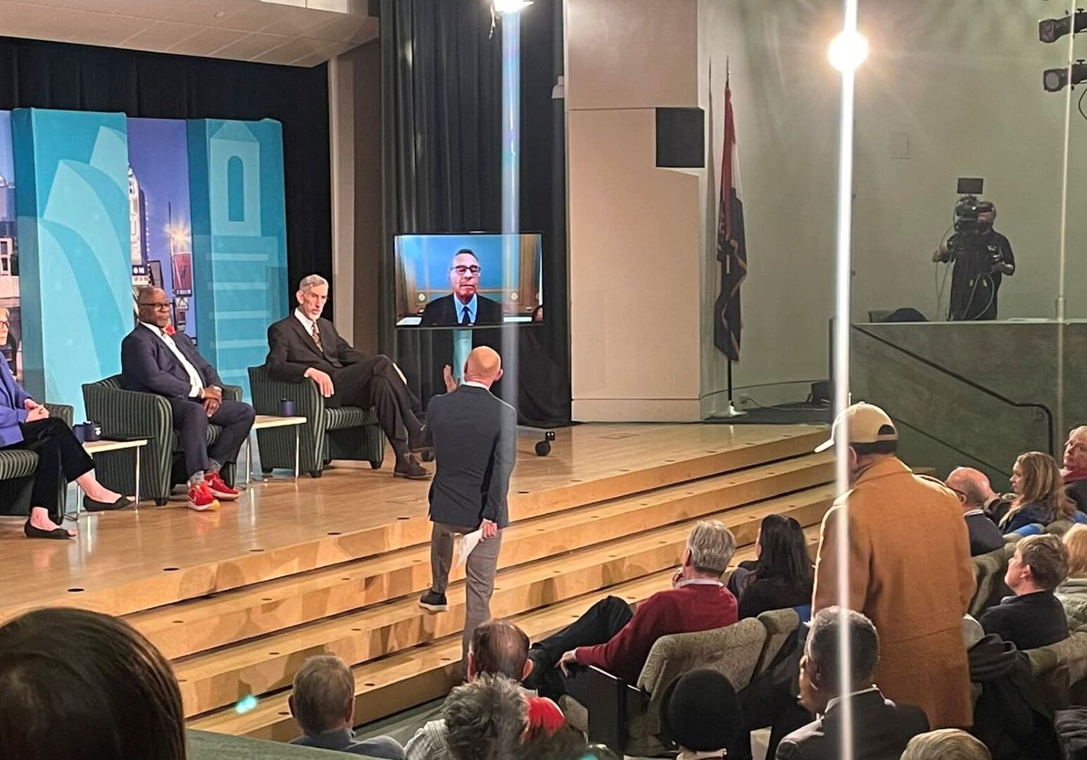 Nick Haines on stage at the Kansas City Public Library's Country Club Plaza branch moderating a public conversation with former Kansas City mayors Kay Barnes, Sly James, Mark Funkhouser and Emanuel Cleaver.