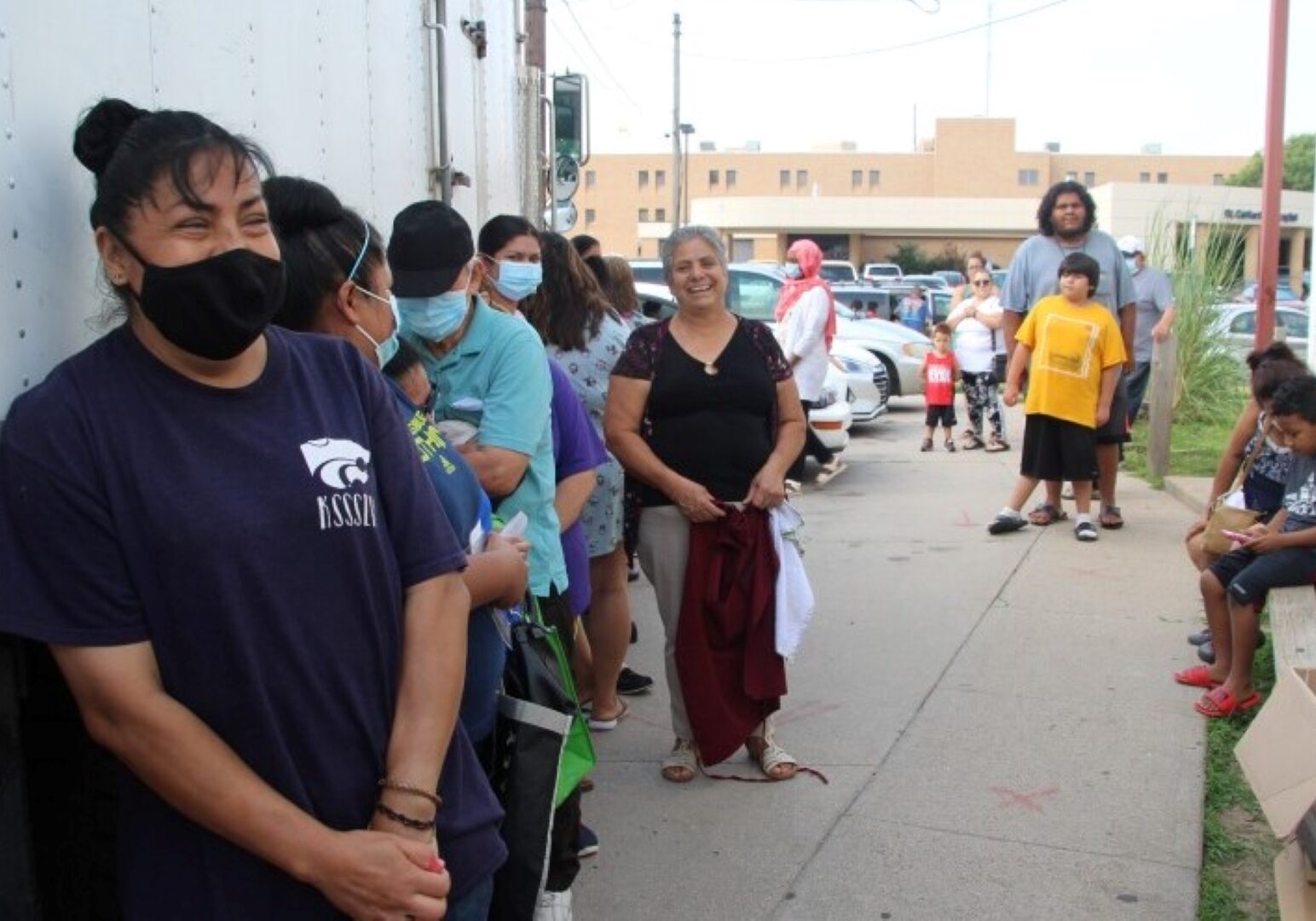 A line of people wait for the food pantry to open at Emmaus House. Maria Hernandez, center, cooks for the shelter's soup kitchen in addition to helping pass out groceries.