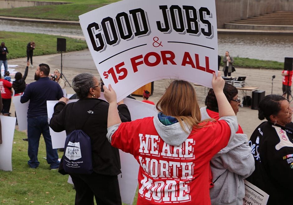 Picture of people marching and holding sign that says "Good Jobs, $15 for all"
