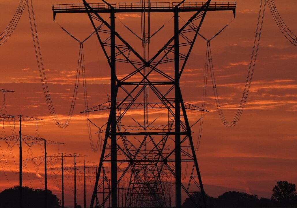 Power lines with a red sunset in the background.
