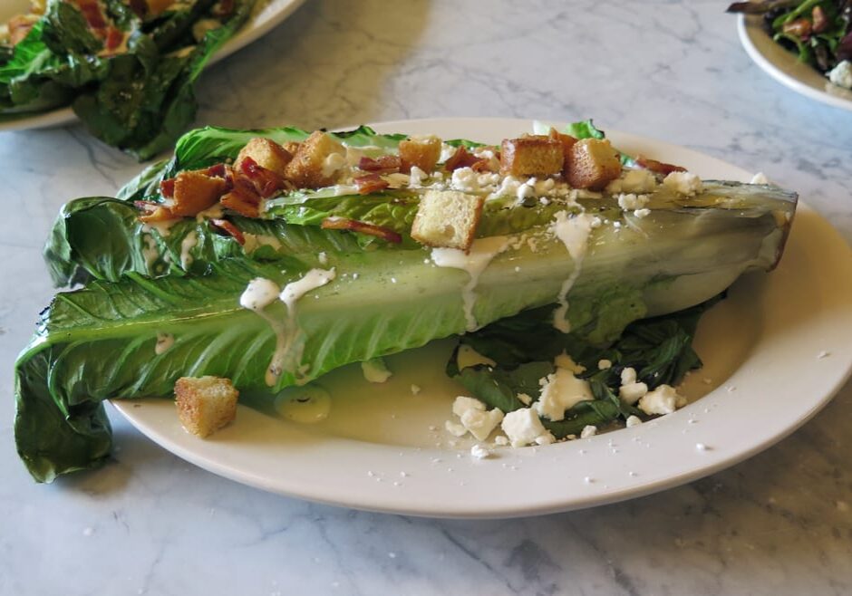 grilled romaine salad with bacon and feta cheese.