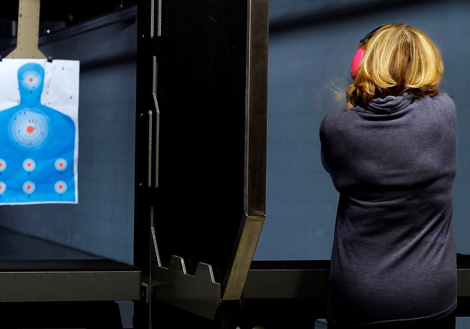 A woman takes aim at a target on the shooting range at Frontier Justice in Lee's Summit, Mo.
