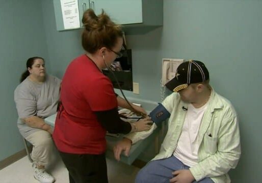 Man having blood pressure taken while woman looks on