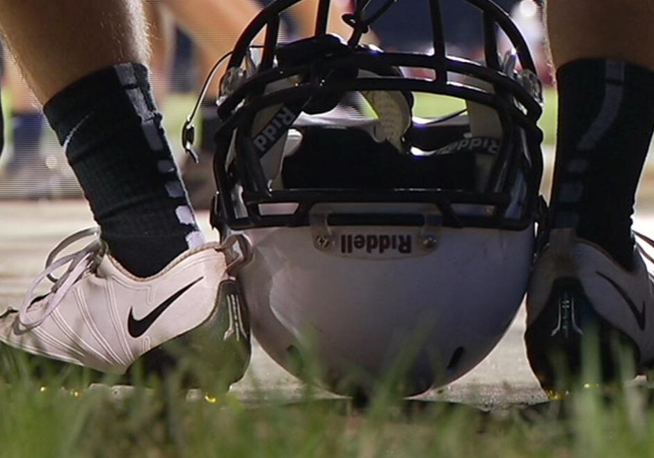 Image of football player's cleat clad feet with helmet.