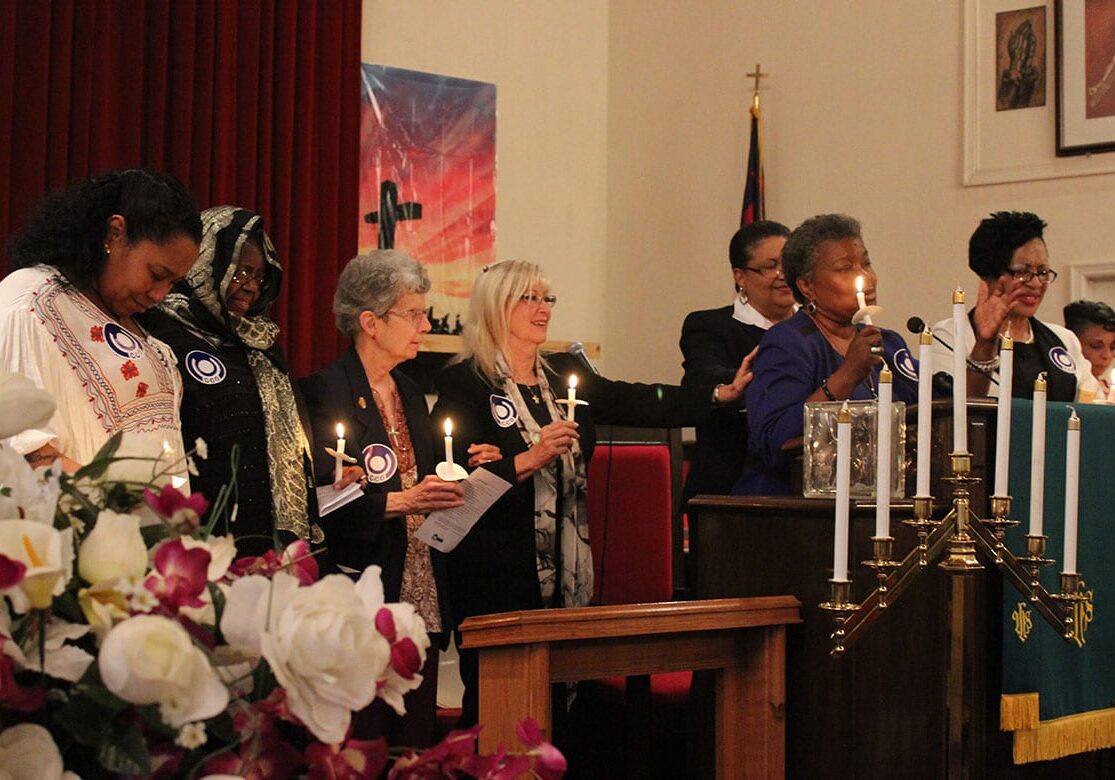 Female members of different faiths sing together at the Mother's Prayer Community Vigil. 
