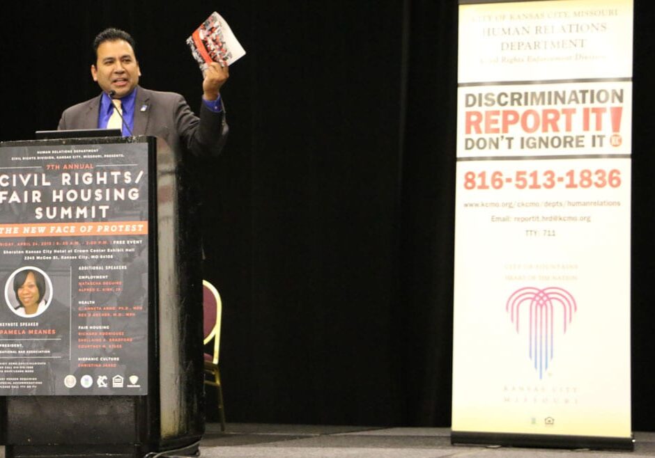 Carlos Gomez, president of the Hispanic Chamber of Commerce of Greater Kansas City, holds up the program from today's Civil Rights Summit. He applauded the city for printing the schedule in English and Spanish — the first instance of this he had seen in his eight years with the chamber. Photo by Caitlin Cress, Flatland. 