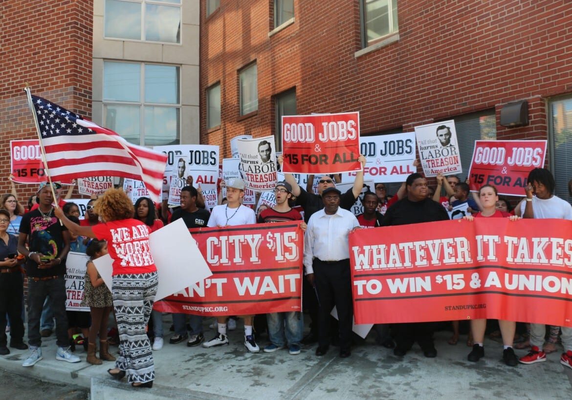 Protestors stand outside building