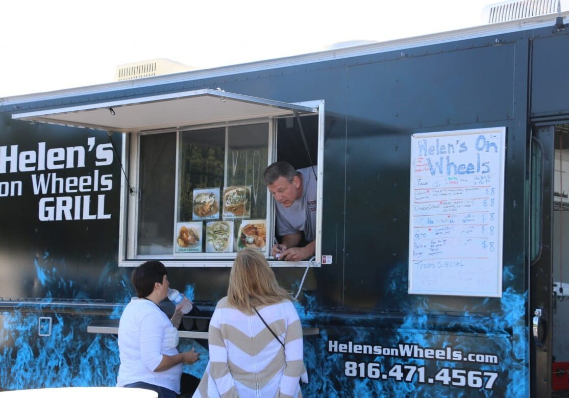 Food truck owner takes orders from two females.