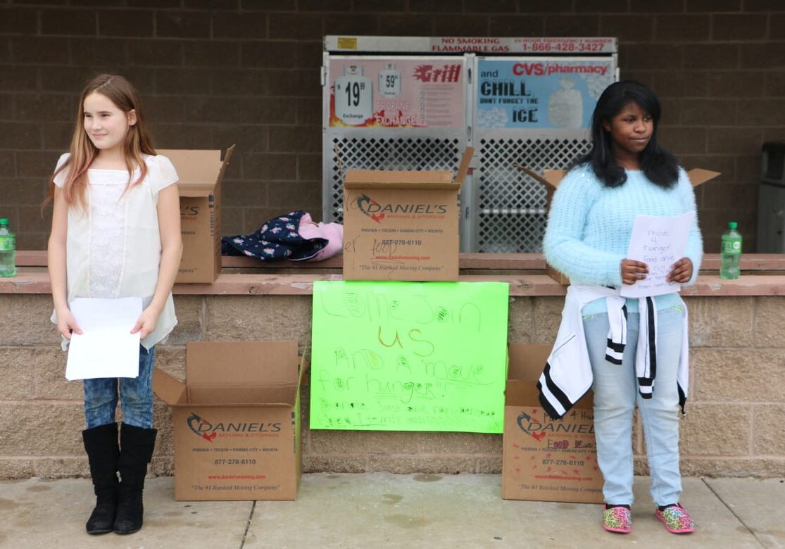 Lexi Brewer, 11 (left) and her best friend Alyna Woodley (right) ended up filling all five boxes with food and goods for the homeless food bank Saturday afternoon. (Photo: Daniel Boothe | Flatland) 
