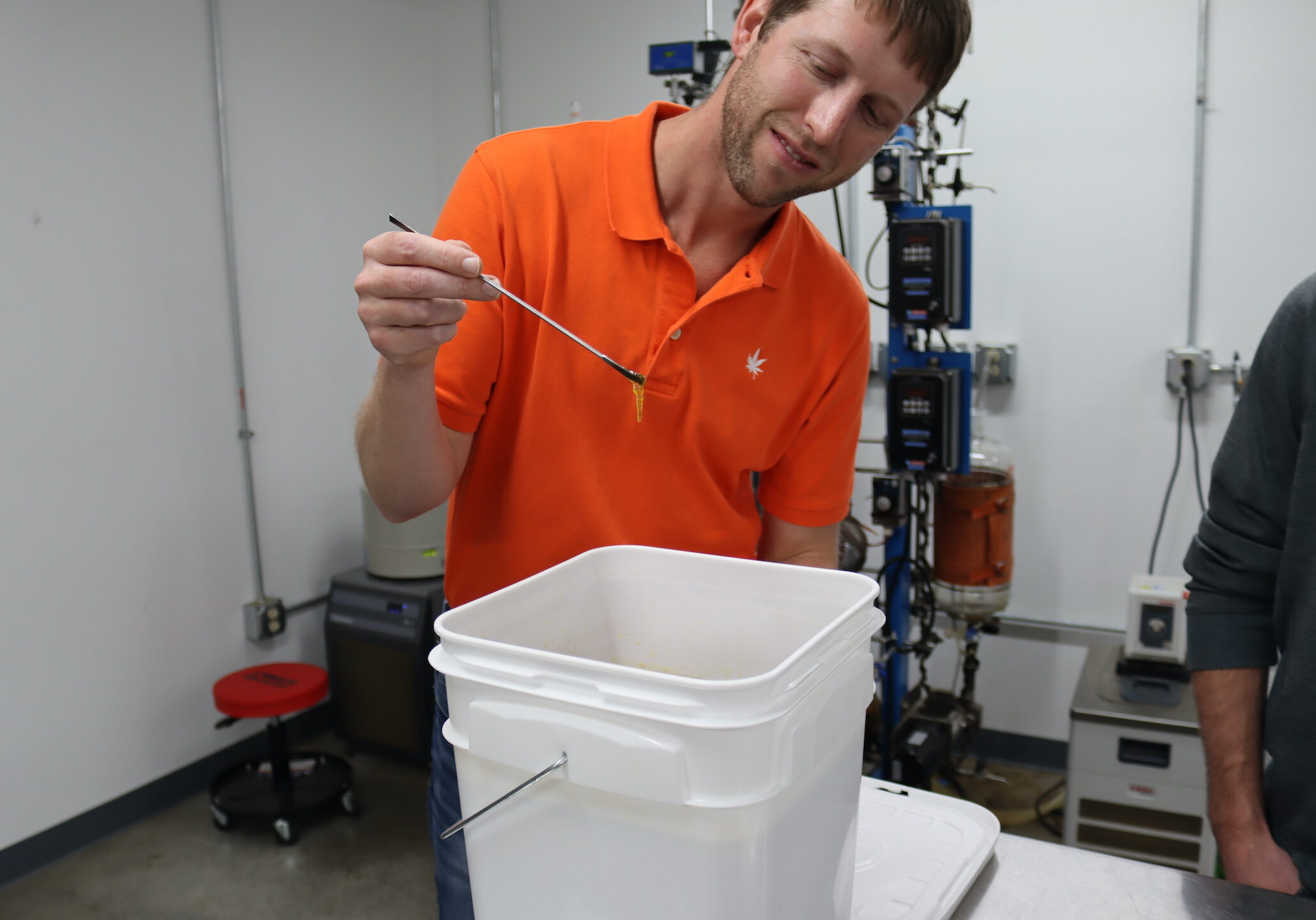 A man drips CBD extract into a bucket.