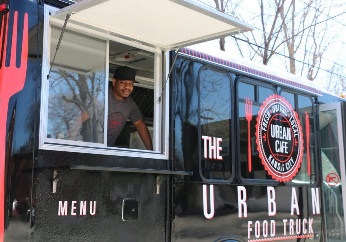 A man ready to serve food out of his food truck.