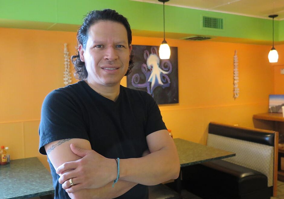 A man standing in his restaurant.