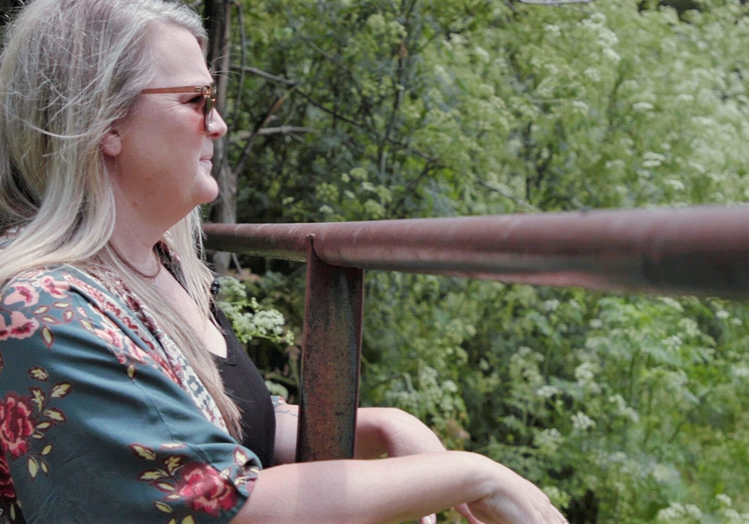 Jessica Piper is seen in profile with trees in the background.