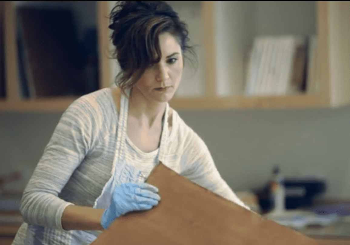 Local artist Julie Hansen working in studio. Still taken from Brad Austin's short documentary about Hansen.