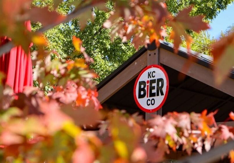 KC Bier Co. sign among colorful fall leaves.