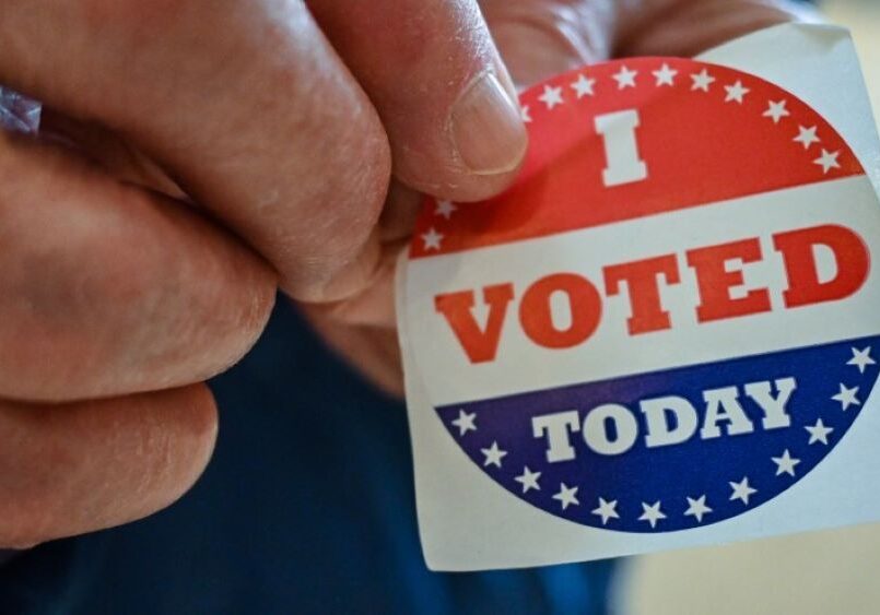 A man holding an "I Voted Today" sticker.