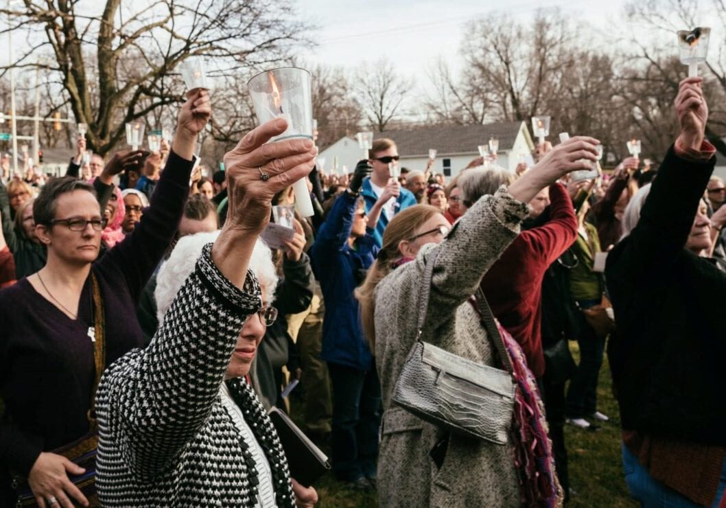 People raise their candles as a commitment to contact their representatives on behalf of immigrants and refugees.