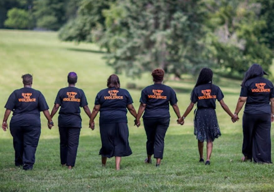 Members of KC Mothers in Charge holding hands in solidarity in Kansas City, Missouri.