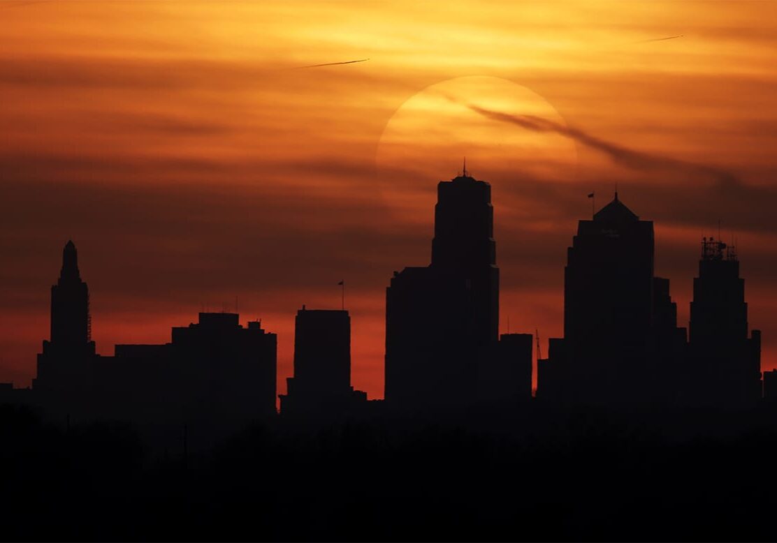FILE - The sun sets behind the downtown Kansas City, Mo. skyline as above average temperatures returned to the region Thursday, March 14, 2013. Government forecasters say much of the United States can expect a warm spring and persistent drought. The National Weather Service said Thursday, March 21, 2013 above-normal temperatures are predicted across most of the Lower 48 states and northern Alaska. (AP Photo/Charlie Riedel)