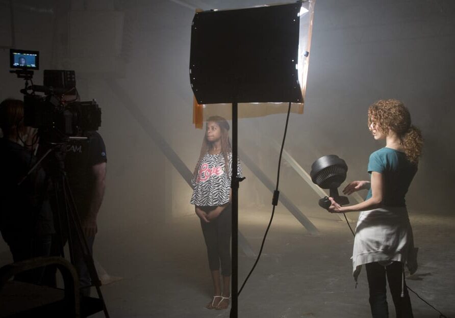 Image of woman being filmed on set.