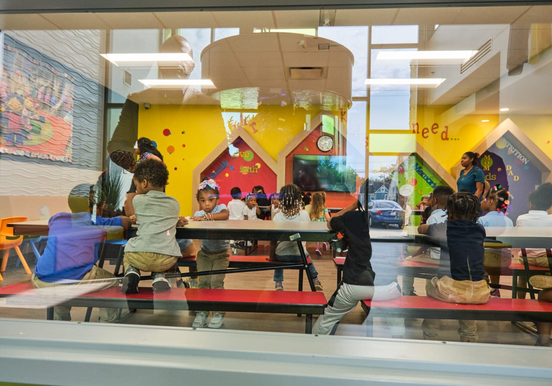 Founder Myron McCant looks through a window at the children served at KD Academy child care.