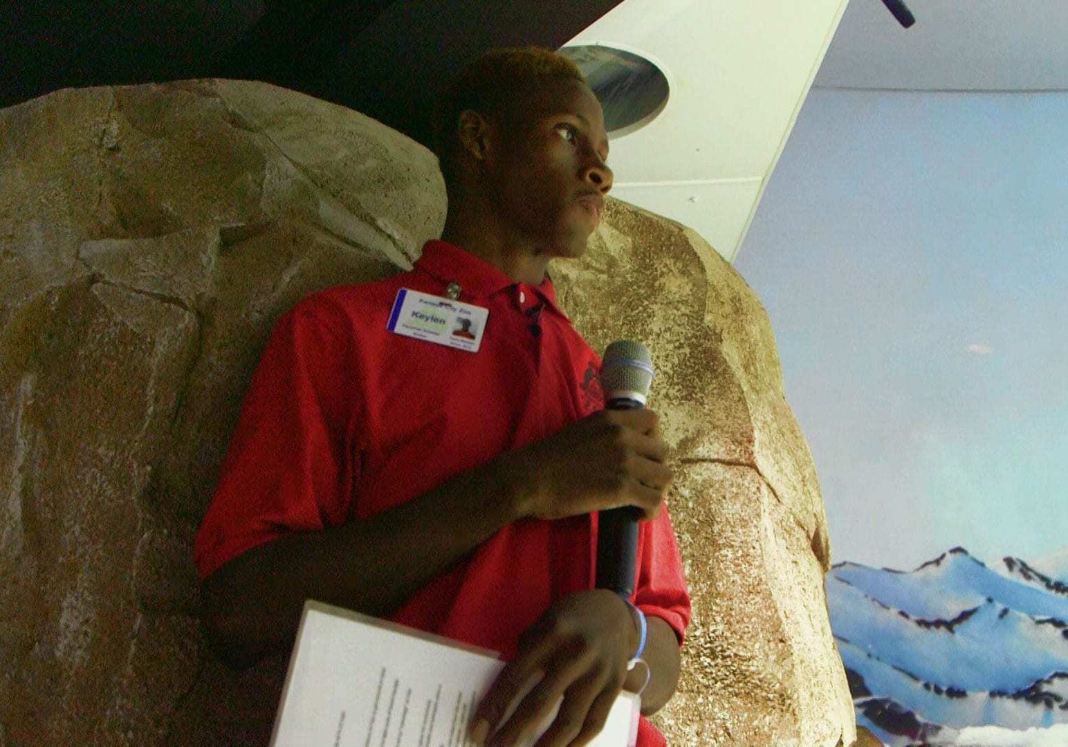 Green Works KC student Keylen Madge speaking into microphone while giving "Penguin Chat" at the KC Zoo.