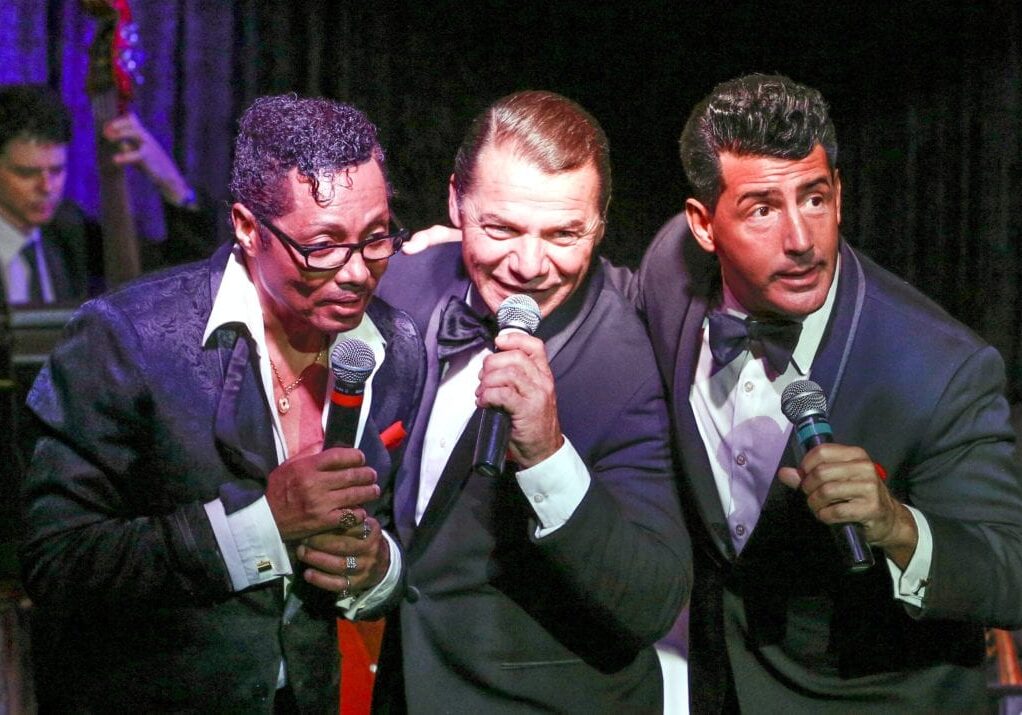 Three men singing on stage.