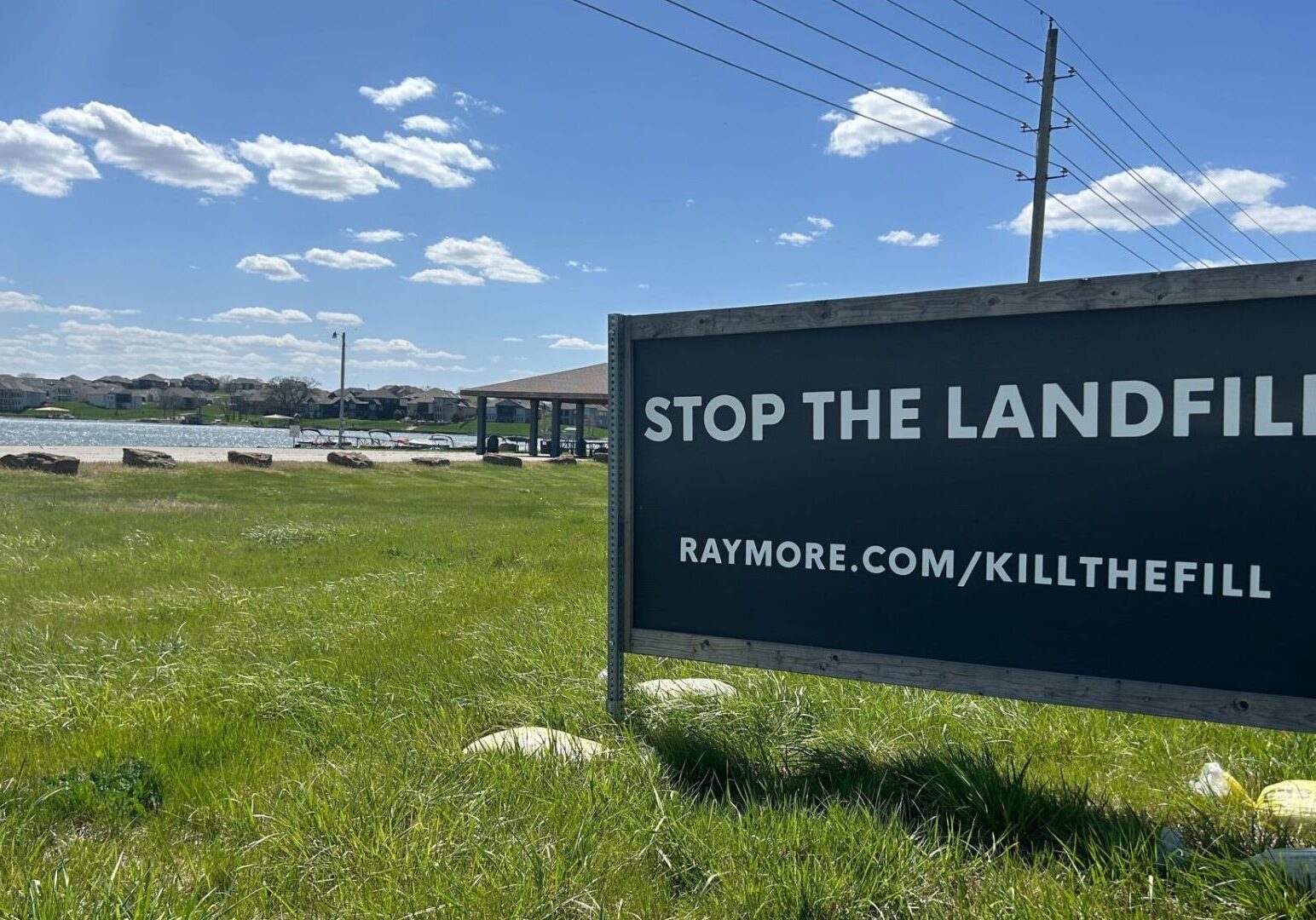 A sign just outside Creekmoor, a golf course subdivision in Raymore, implores drivers to stop a proposed landfill less than a mile away. The Raymore City Council on Monday adopted legislation that would offer a payment to developers of the proposed landfill to abandon their plans for the site.