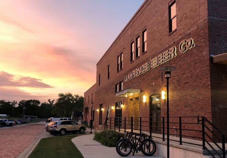 The exterior of Lawrence Beer Co. with the sunset in the background.