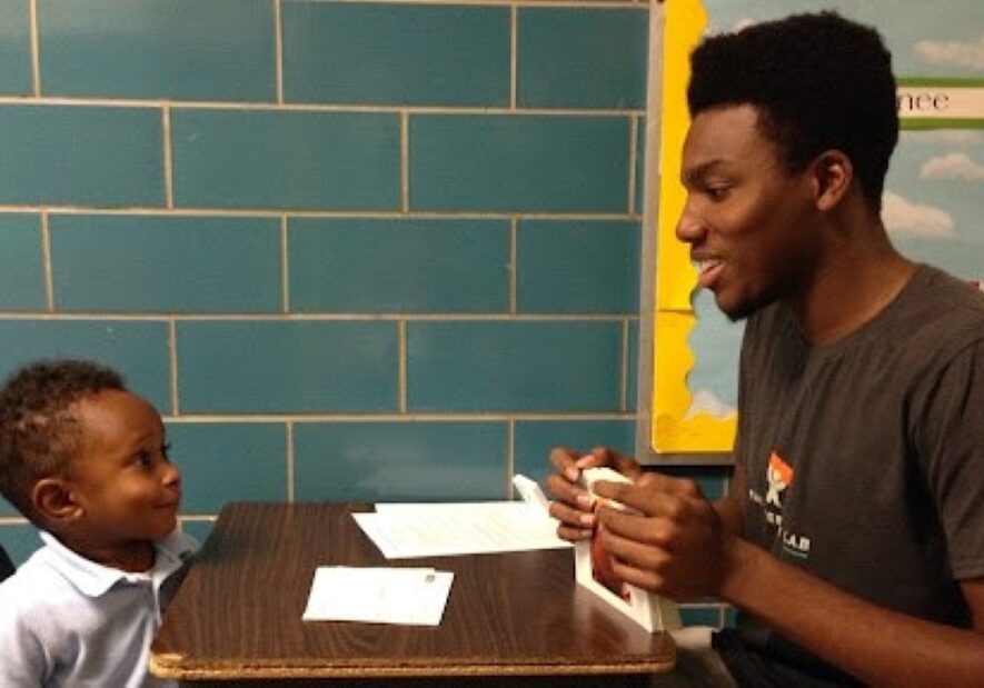 A Literacy Lab tutor teaching during a session with a young student.