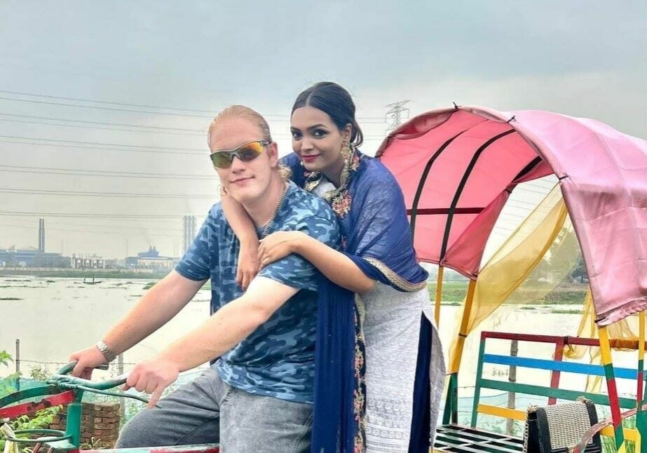 Ryan Coffman and Sayeeda Islam in a traditional Bangladeshi three-wheeled passenger cart.