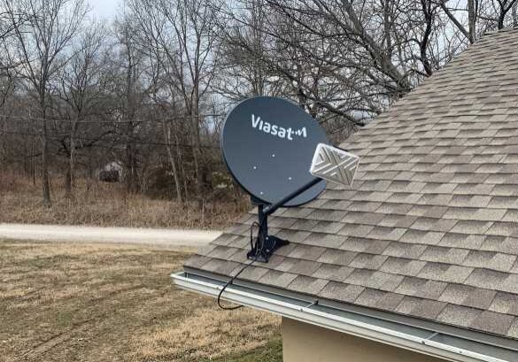 The Black family's satellite outside of their home. When it snows, they have to knock packed snow off of the dish to get a connection.