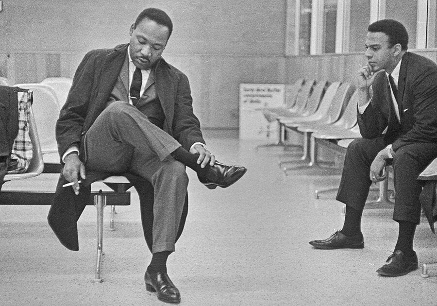 Image: Martin Luther King Jr. hangs his head with a cigarette hanging in his right hand (left) and Andrew Young in 1966 at the Montgomery, Ala., airport. Credit: Bob Fitch, Stanford University Libraries, Department of Special Collections