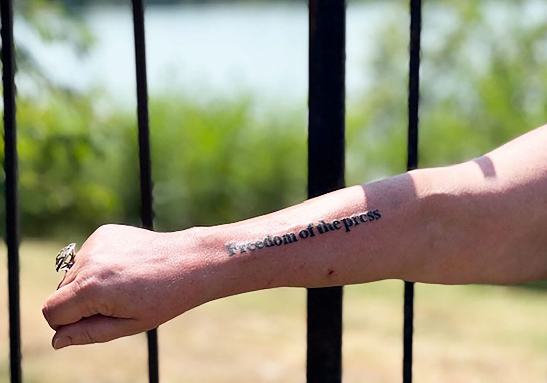 Freedom of the Press tattooed on a woman's forearm.