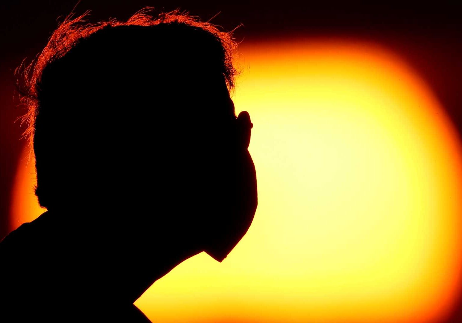Man wearing a mask at sunset.
