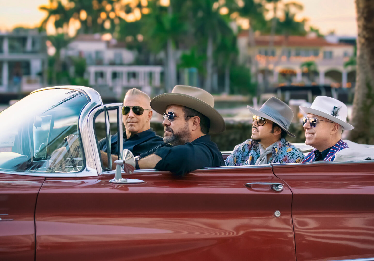 The Mavericks band rides in a convertible.