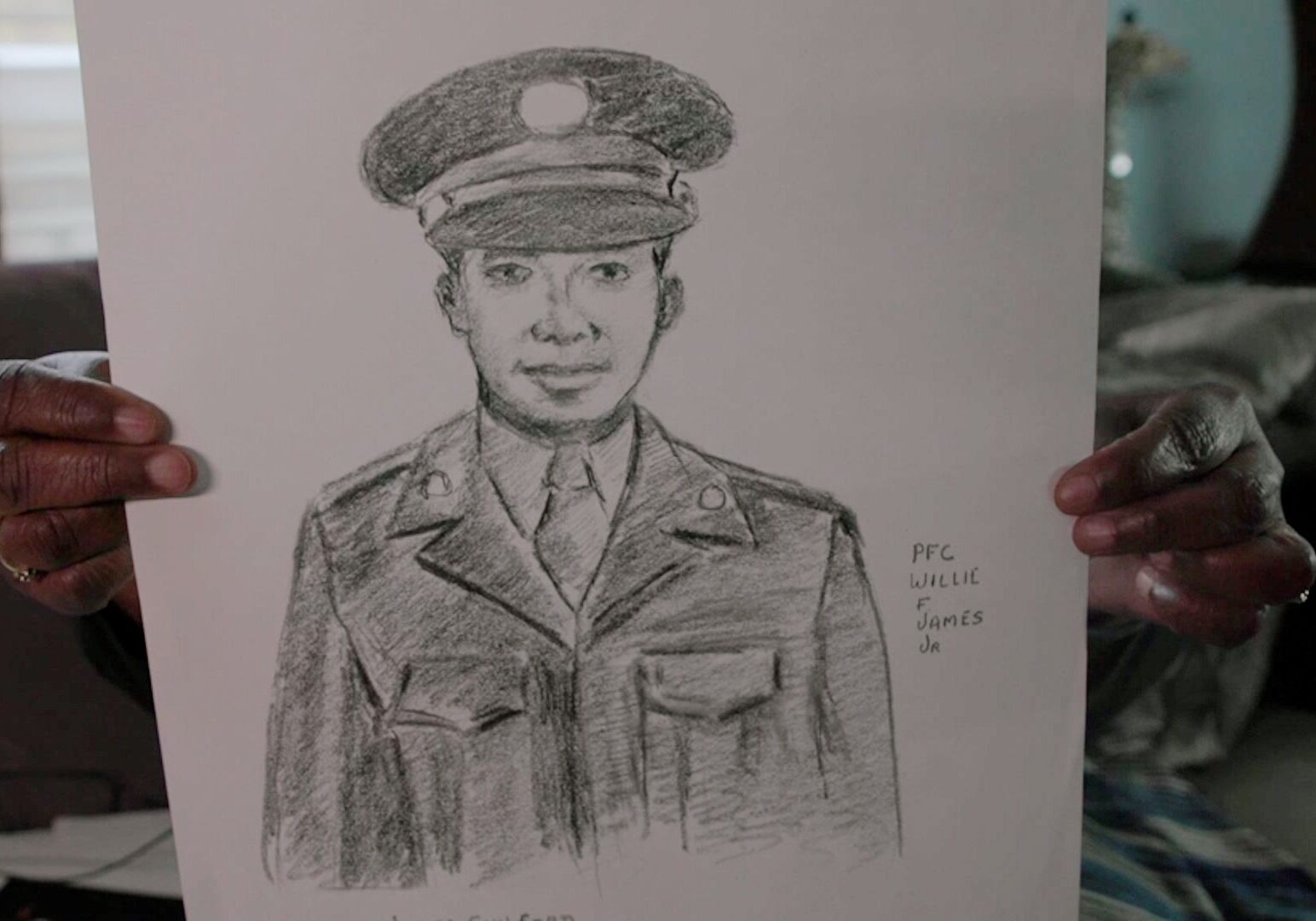 A niece holds up a sketch of Medal of Honor winner Willy F. James Jr.