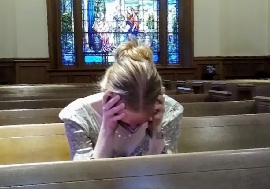 A parishioner sits alone in church.