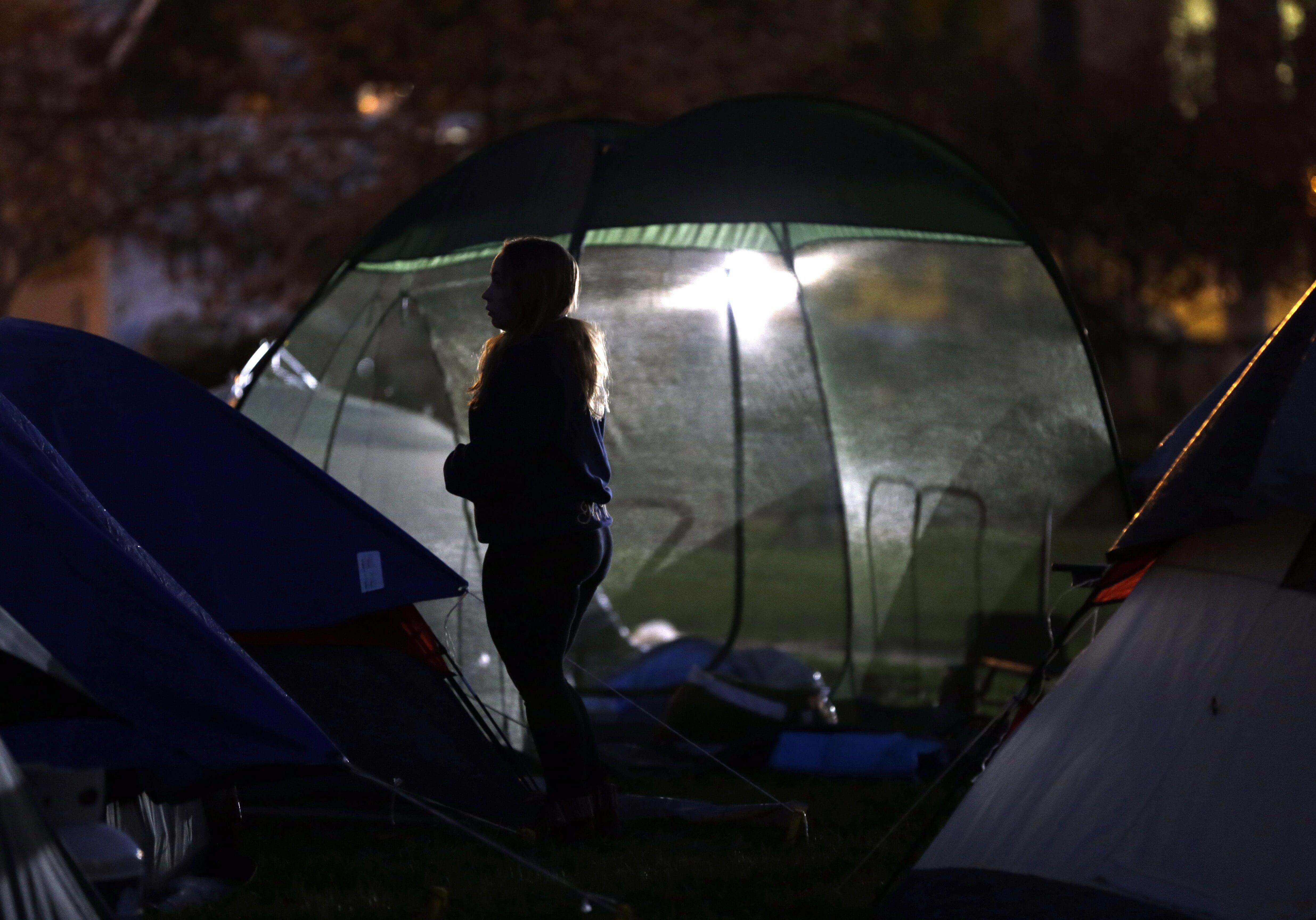 A student protester stands between tents set up in an encampment as night falls Monday, Nov. 9, 2015, on the University of Missouri campus in Columbia, Mo. The developments at MU call for a revisiting of a racist incident in the history of the Missouri School of Journalism, writes KCPT reporter and Missouri School of Journalism alum Mike McGraw. (AP Photo/Jeff Roberson)