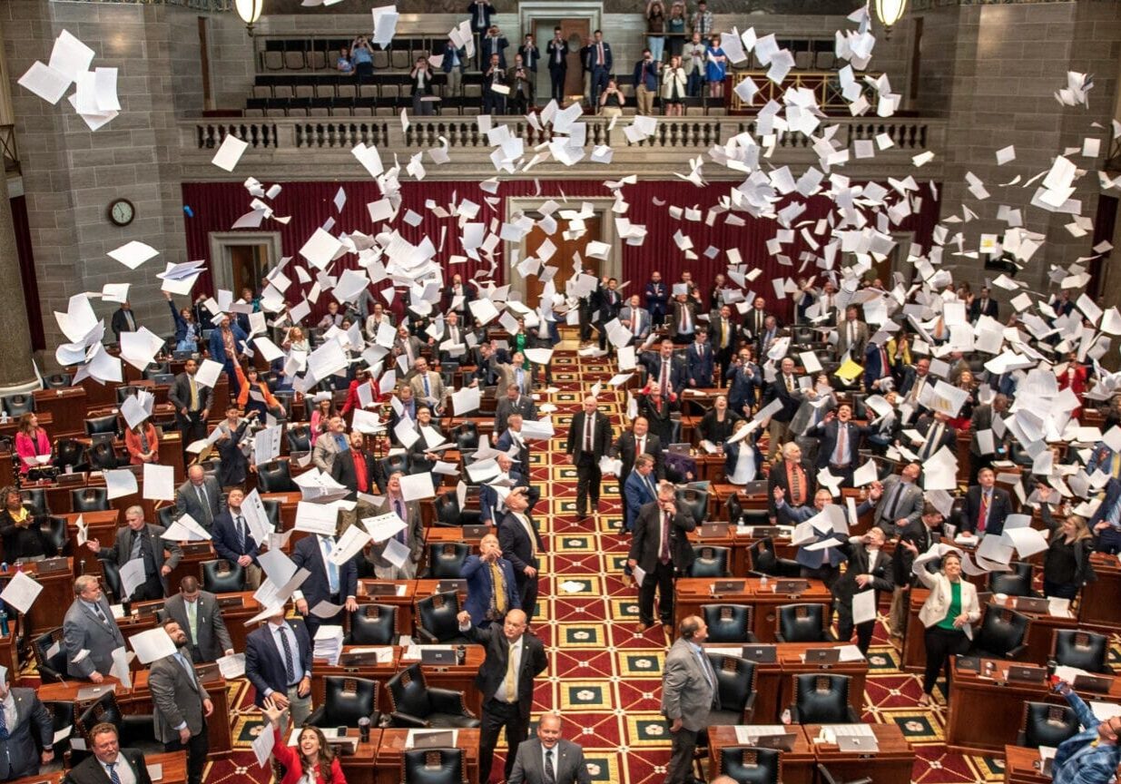 Members of the Missouri House throw paper into the air to celebrate the end of the 2023 legislative session.