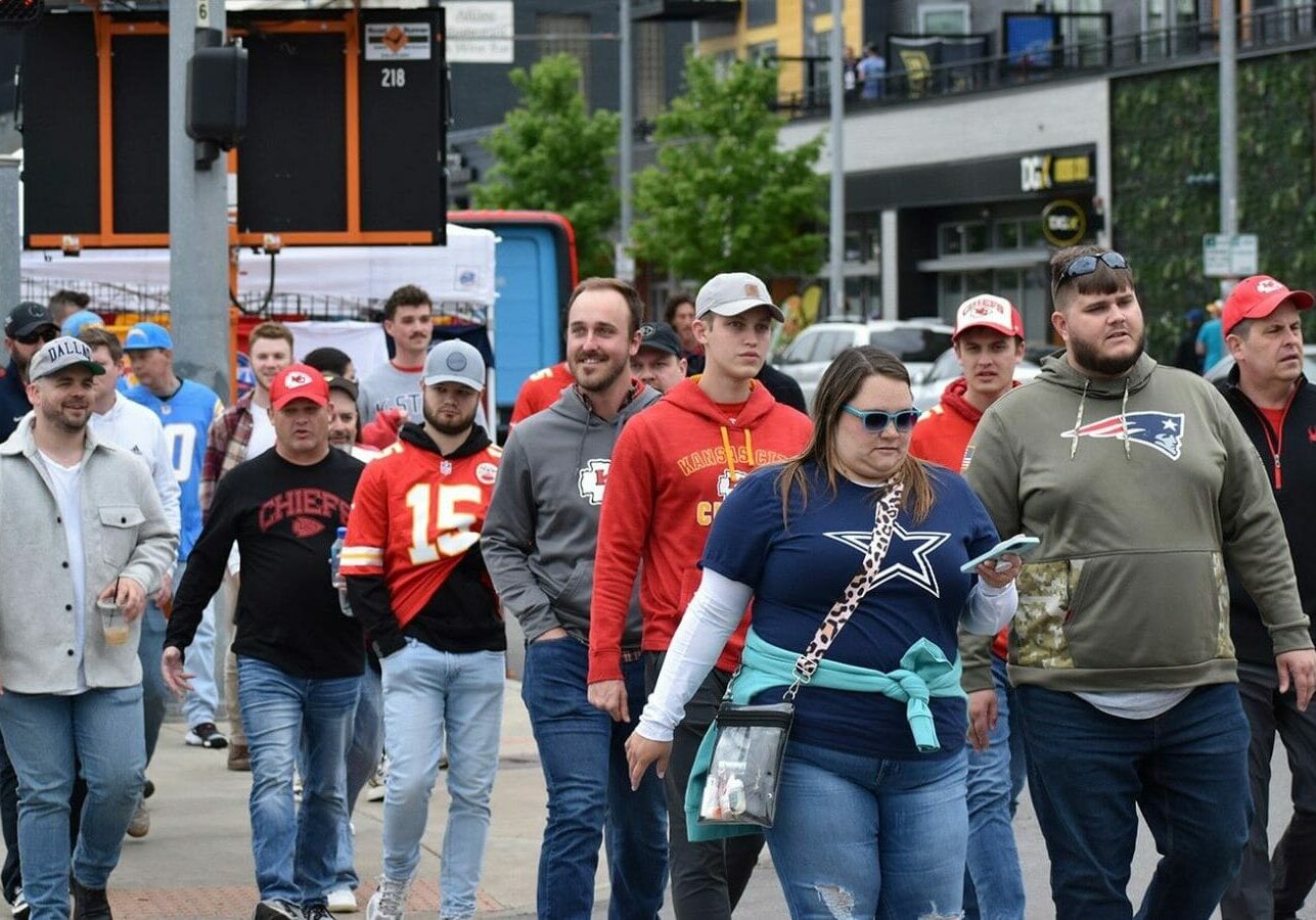 Fans decked out for the NFL Draft walk through the Crossroads Thursday on their way toward Union Station and the NFL Draft event grounds.