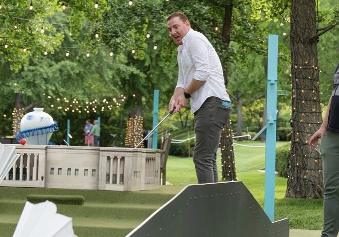 A person plays mini golf on the Nelson-Atkins lawn.